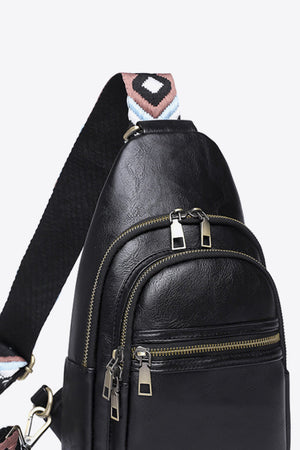 Black sling bag with geometric strap and multiple zippered compartments