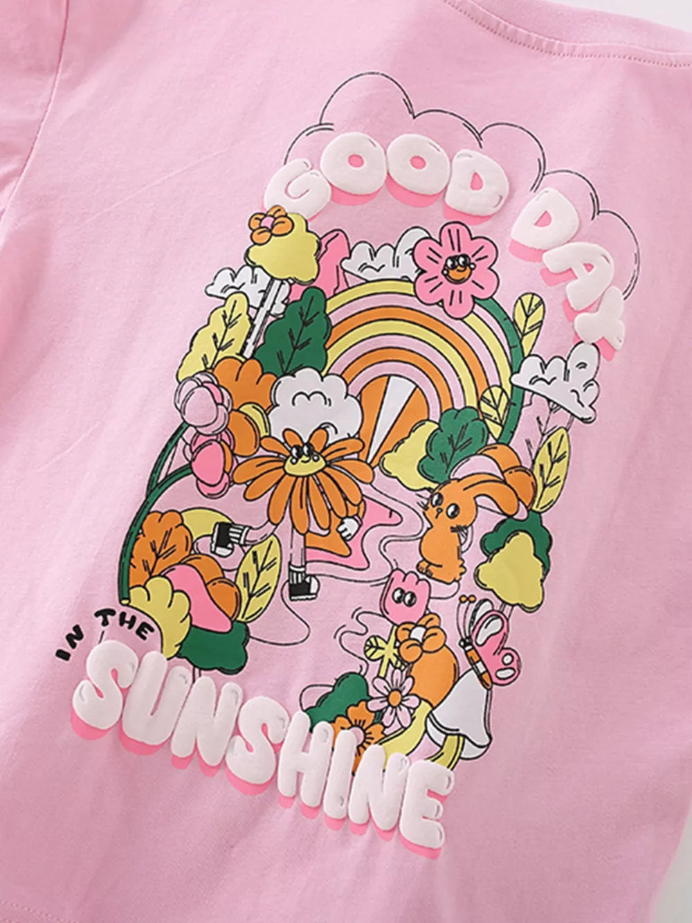 Pink cotton blend toddler girls' t-shirt with a "Good Day in the Sunshine" graphic featuring cartoon characters and flowers.