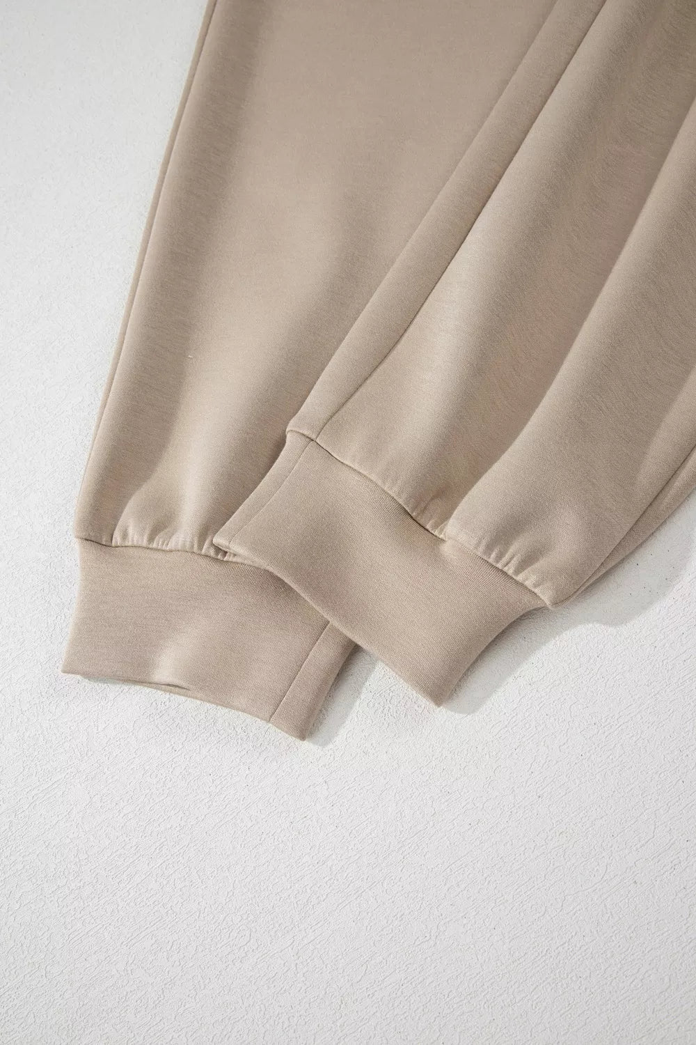 Chic collared romper in beige with ankle cuffs and cap sleeves.
