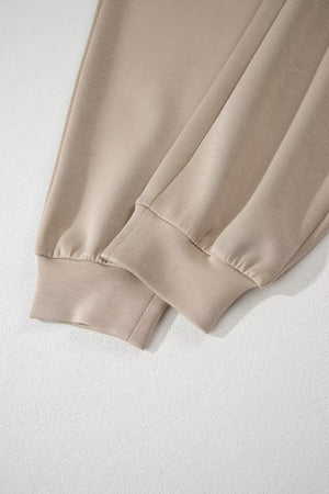 Chic collared romper in beige with ankle cuffs and cap sleeves.