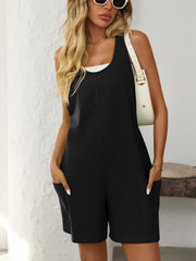 Black sleeveless utility romper with seam details and pockets