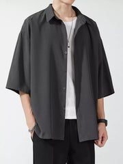 Men's oversized dark gray short sleeve button-up shirt with a relaxed fit.