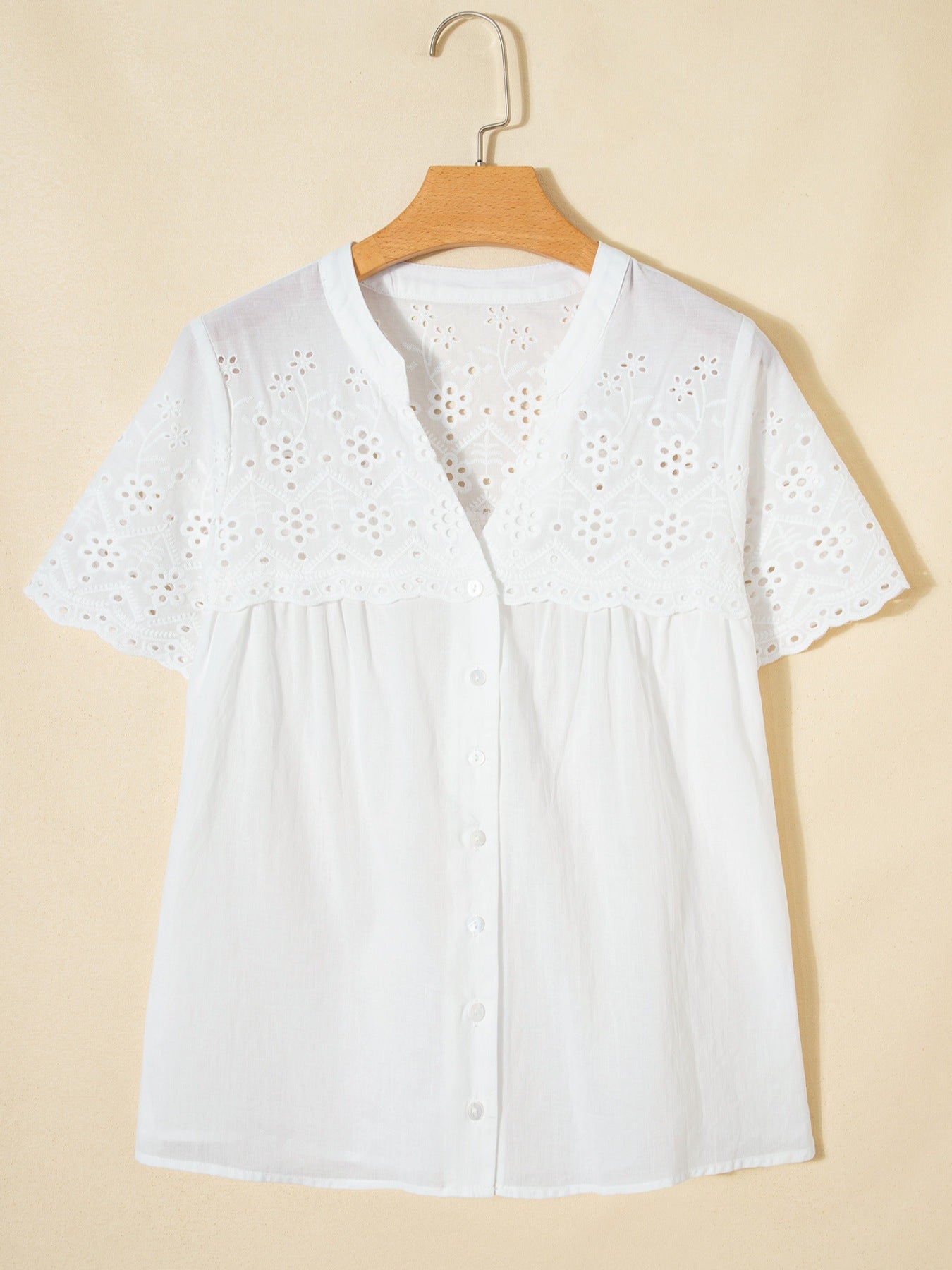 White cotton eyelet embroidered sheer shirt with short sleeves and button front.