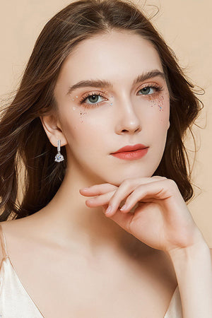 Silver drop earrings with clear crystal accents and a teardrop gem.