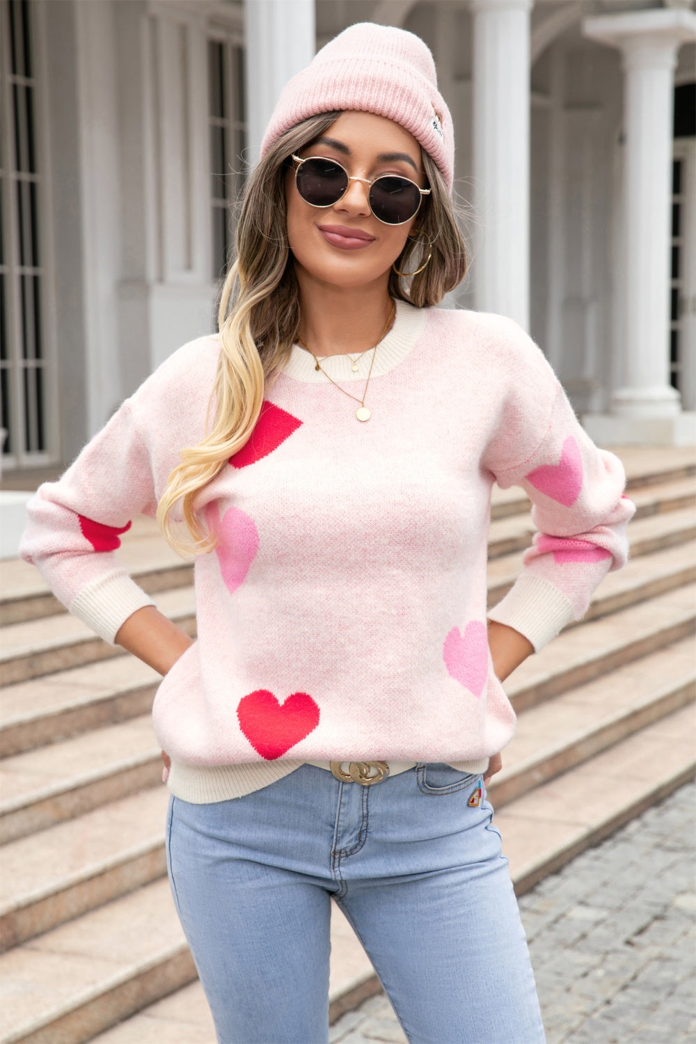 Blush pink intarsia knit crewneck sweater with red and pink hearts.