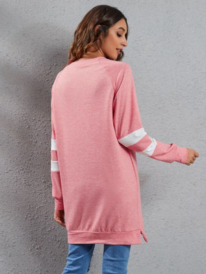 Pink raglan sweatshirt dress with white sleeve stripes, crew neck, and side slits.