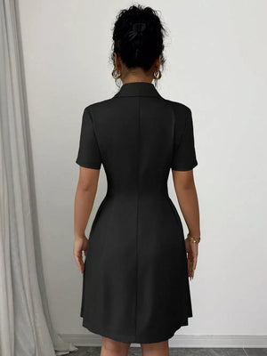 Black double-breasted pleated blazer dress with short sleeves and a collared neckline.