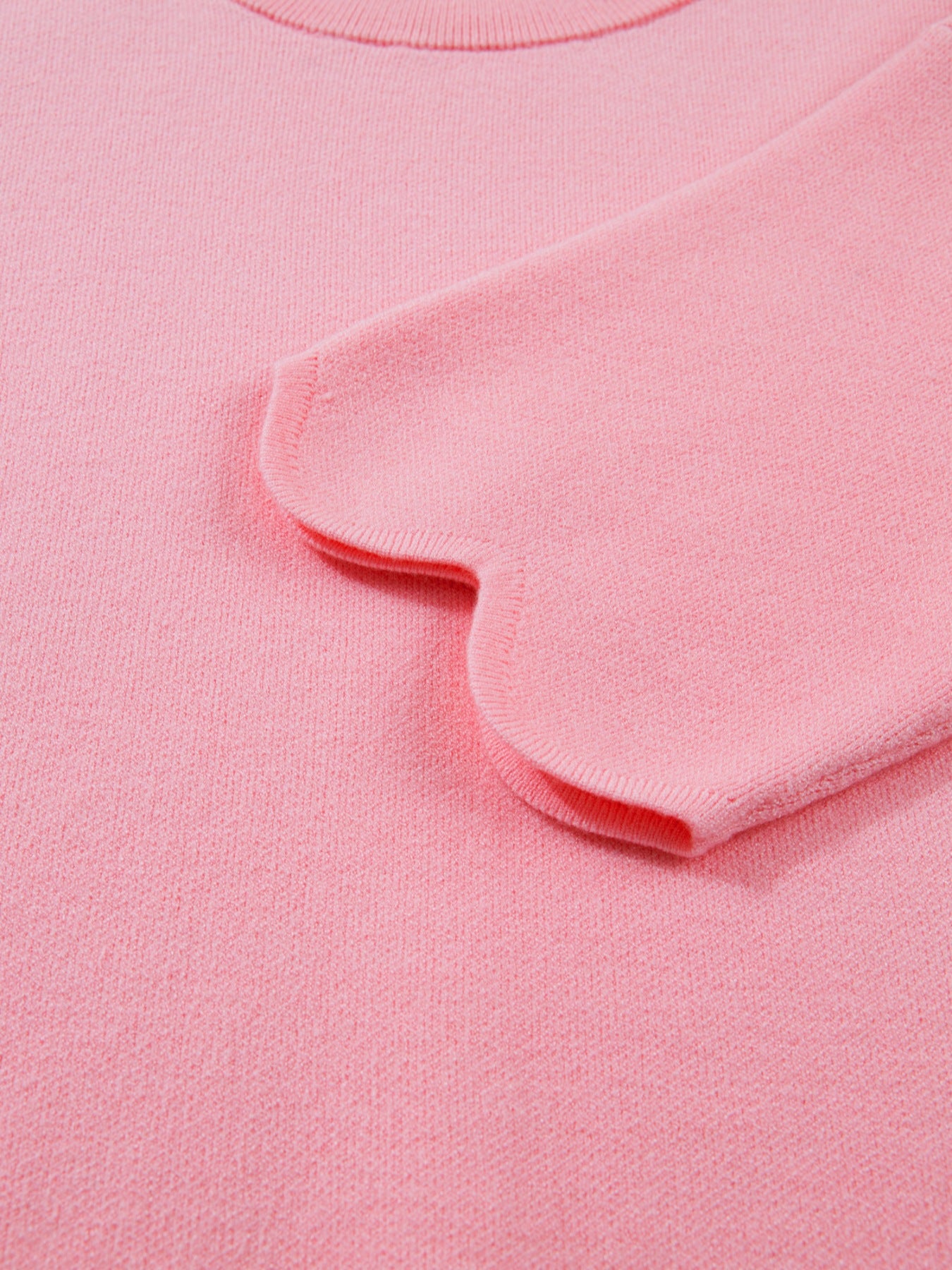 Pink knit sweater with scalloped sleeve detail