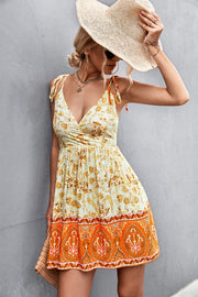Bohemian print mini dress in light yellow with tie straps and orange border detail.