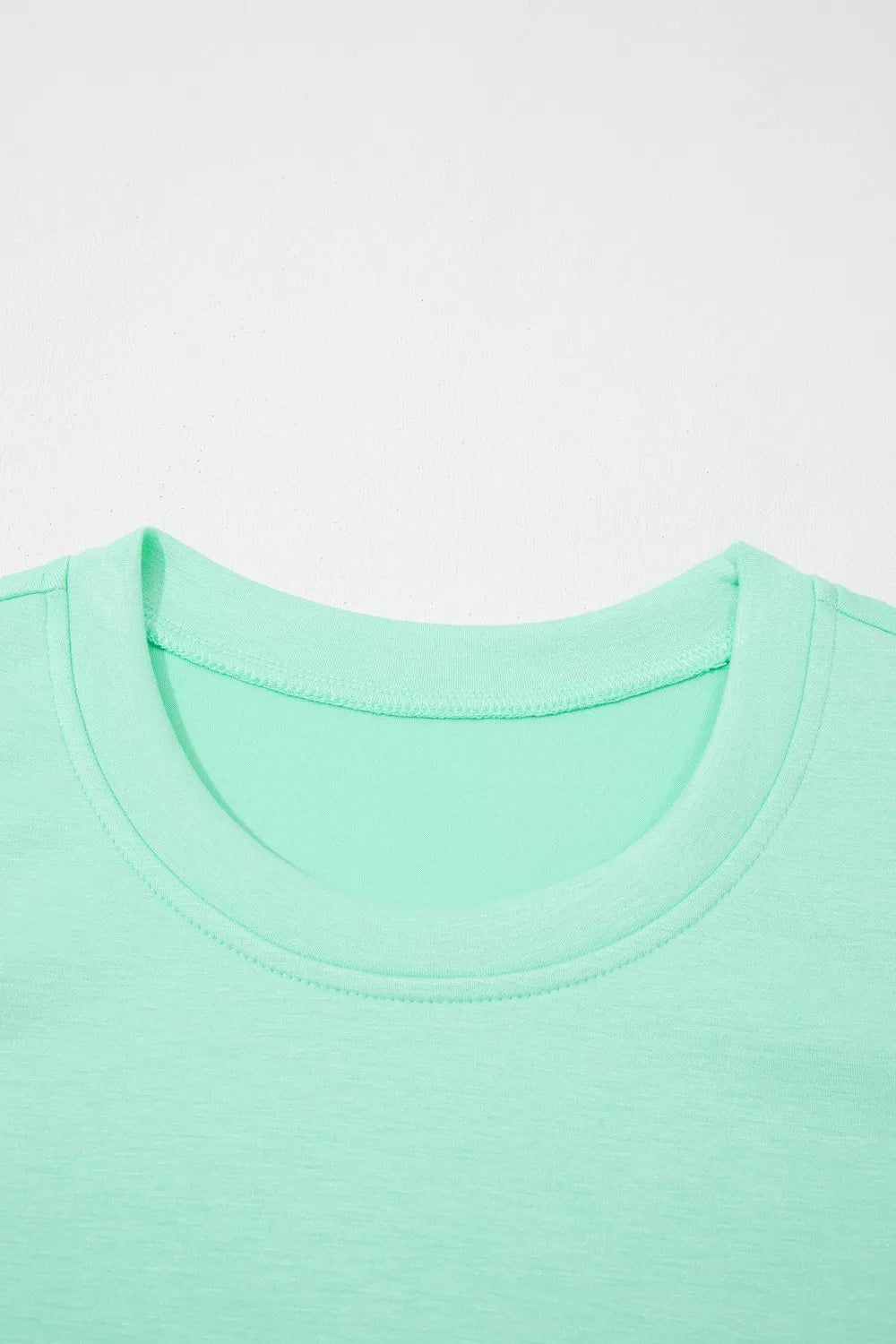 Mint green two-piece lounge set t-shirt with crew neck and visible stitching detail.