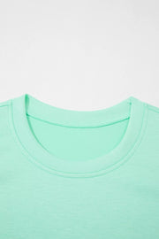 Mint green two-piece lounge set t-shirt with crew neck and visible stitching detail.