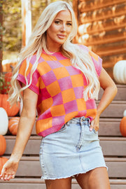 Checkerboard knit cap-sleeve top in plaid orange and pink with a crew neck.