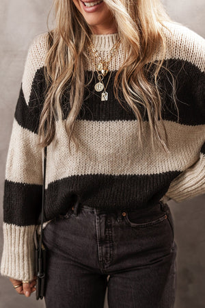 Relaxed knit sweater with bold black and cream stripes, crewneck, and long sleeves.