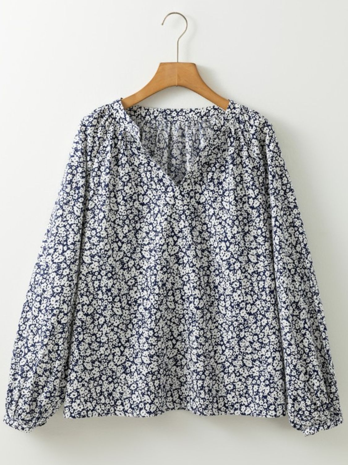 Blouse with allover floral print, V-neck, and long sleeves.