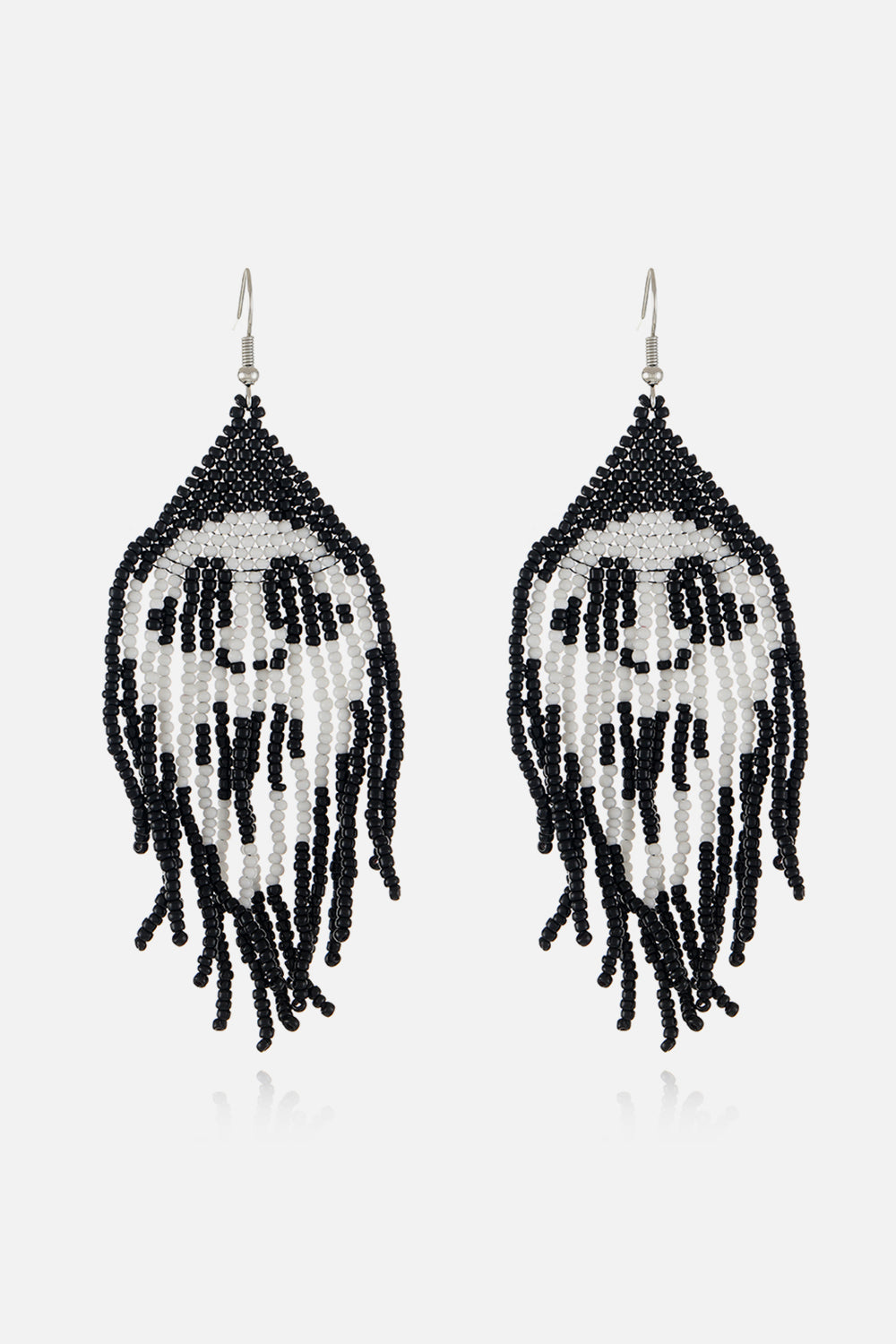 Beaded skull fringe earrings in black and white with dangling strands.