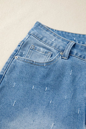 Light wash denim jeans with high-rise waist and distressed details.