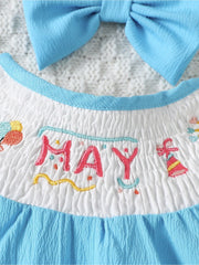 Embroidered May birthday motif white cotton baby one-piece with blue trim and bow.
