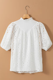White eyelet puff-sleeve blouse with stand collar and ruffled neckline.