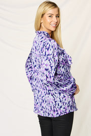 Blue purple abstract print blouse with ruffle front and high neckline.