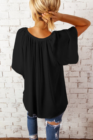 Black relaxed V-neck blouse with cap sleeves and gathered neckline detail.