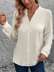 Cream lace sleeve raglan blouse with button front and textured fabric.