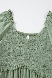 Sage smocked mini dress with V-neck, frill trim, and short sleeves.