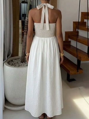 Halter neck maxi dress with beige smocked bodice and white textured skirt.