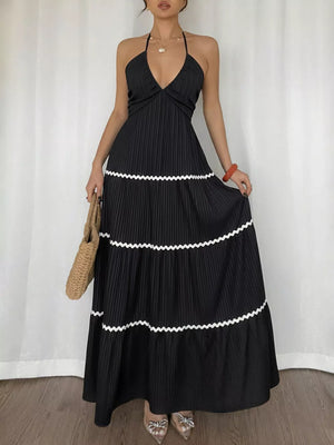 Black ruched halter maxi dress with tiered skirt and white ric rac trim.