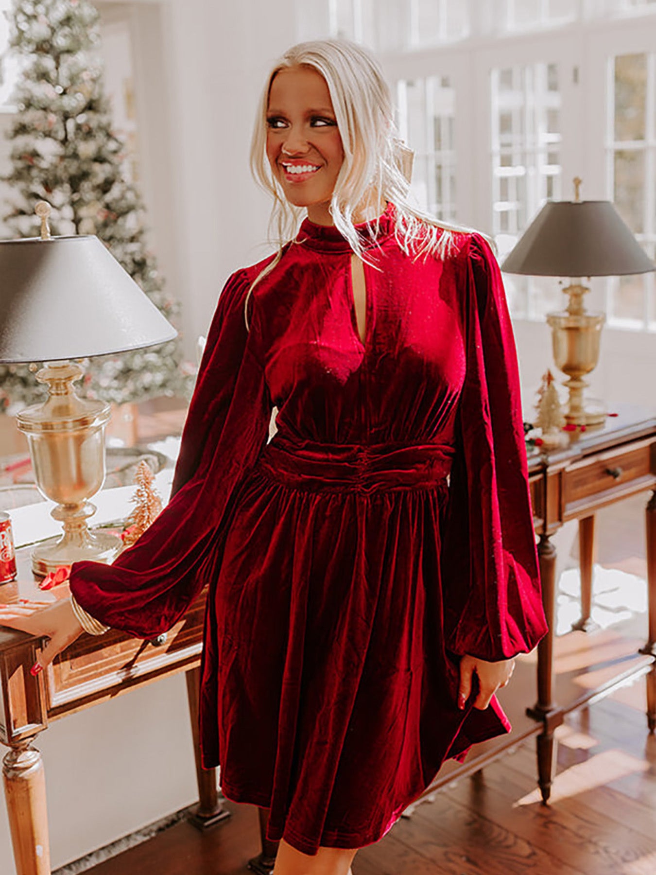 Burgundy velvet mock neck dress with balloon sleeves and cinched waist.