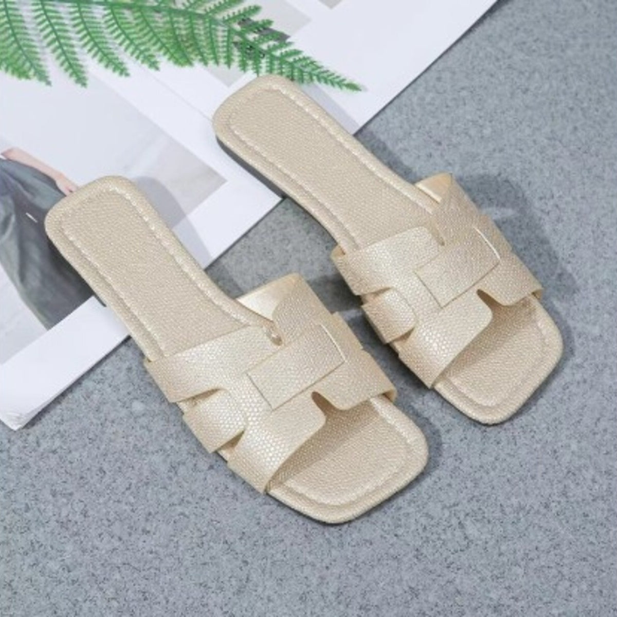 Beige woven strap flat sandals with chic design and textured finish.