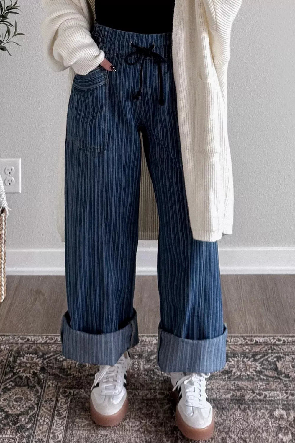 Dark striped wide-leg maternity jeans with drawstring and cuffed hems.