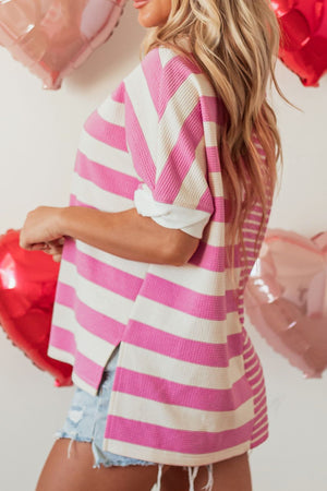 Pink and cream stripe waffle knit top with short sleeves and side slits.
