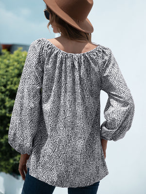 Off-the-shoulder black and white spotted print blouson top with balloon sleeves.