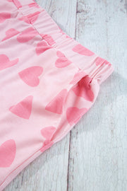 Blush pink lounge pants with all-over heart print and side pockets.