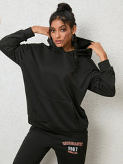 Black graphic hoodie with front pocket and matching joggers with text detail.