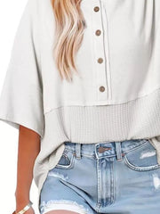 White waffle-knit t-shirt with button detail and textured hem.