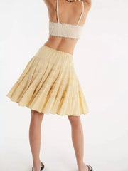 Tiered drawstring mini skirt in pastel yellow with subtle horizontal stitching detail.