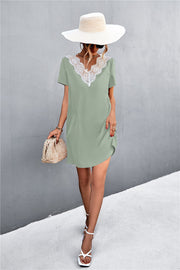 Green v-neck shift dress with lace trim, short sleeves, and a relaxed fit.
