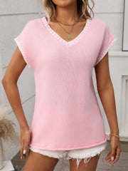 Blush pink knit V-neck sweater top with white contrast trim on neckline and sleeves.
