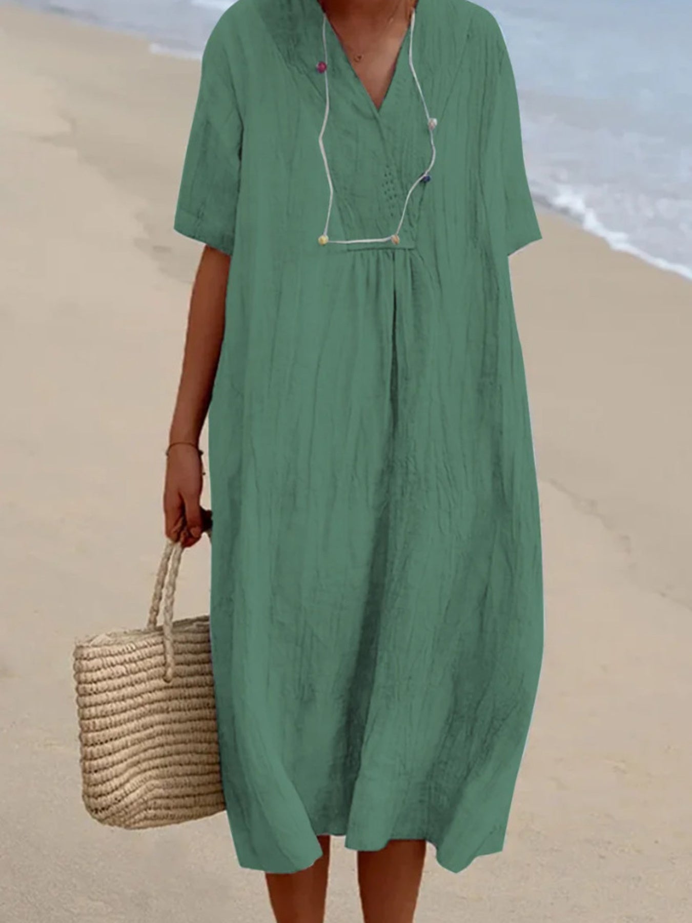 Green V-neck casual midi dress with short sleeves and textured fabric.