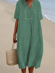 Green V-neck casual midi dress with short sleeves and textured fabric.