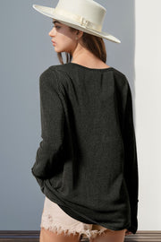 Black waffle knit henley shirt with thumbhole cuffs and a relaxed fit.