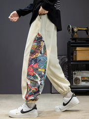 Men's off white joggers with vibrant bird print side panels and elastic cuffs.