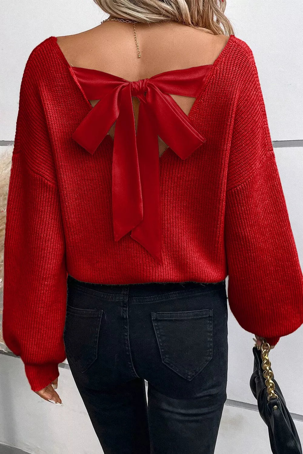 Red knit sweater with backless detail and velvet bow accent