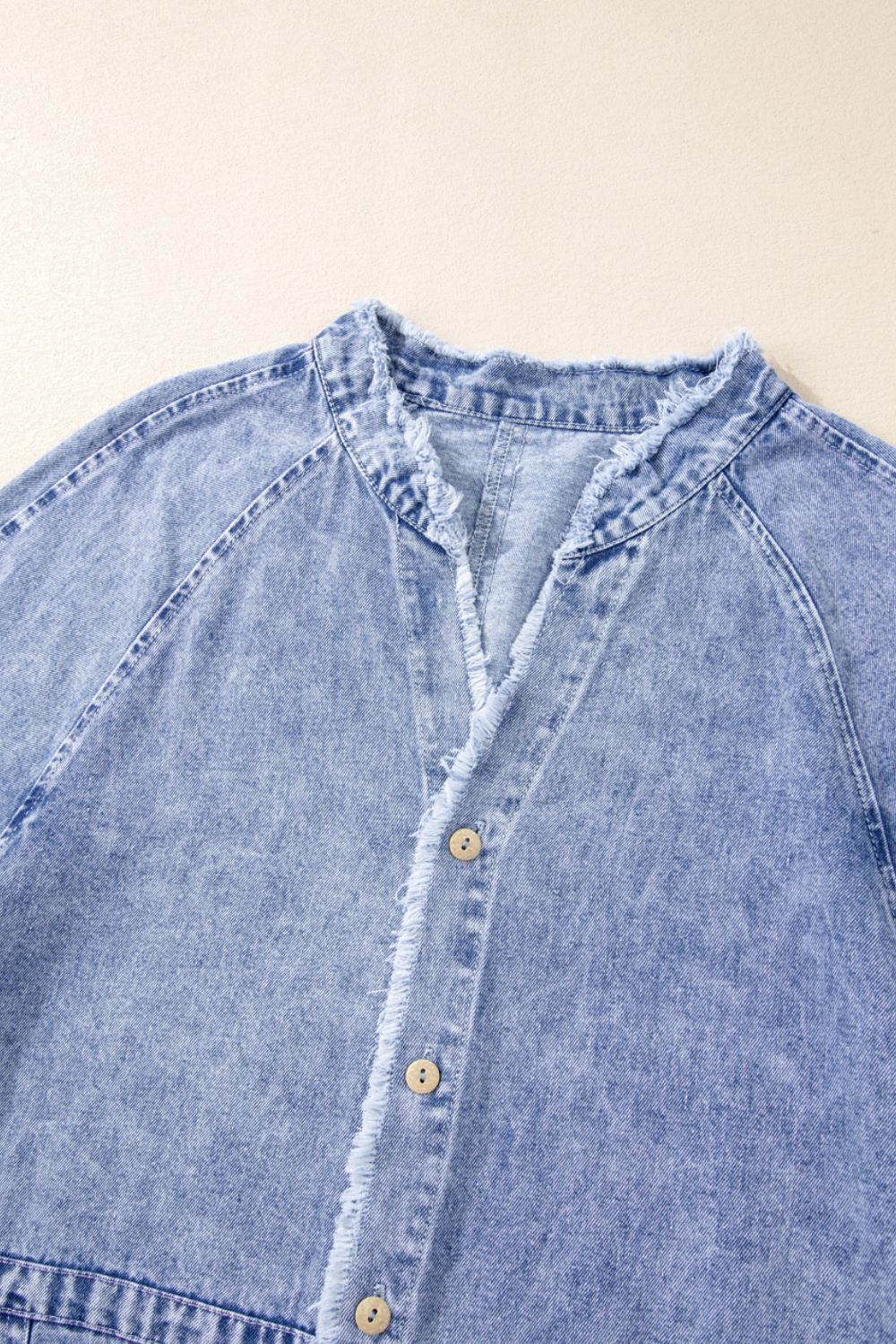 Acid wash denim shirtdress with raw hem, band collar, and button front in medium.