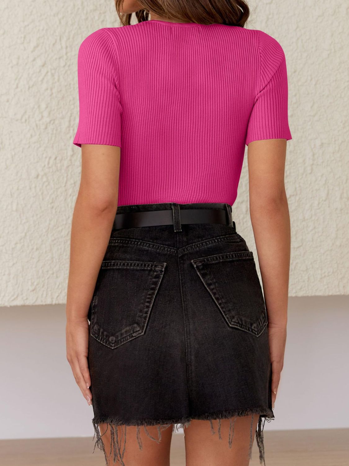 Fuchsia pink ribbed knit t-shirt with short sleeves and a crew neck, styled with black denim shorts.