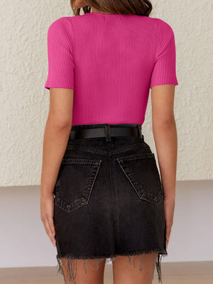 Fuchsia pink ribbed knit t-shirt with short sleeves and a crew neck, styled with black denim shorts.