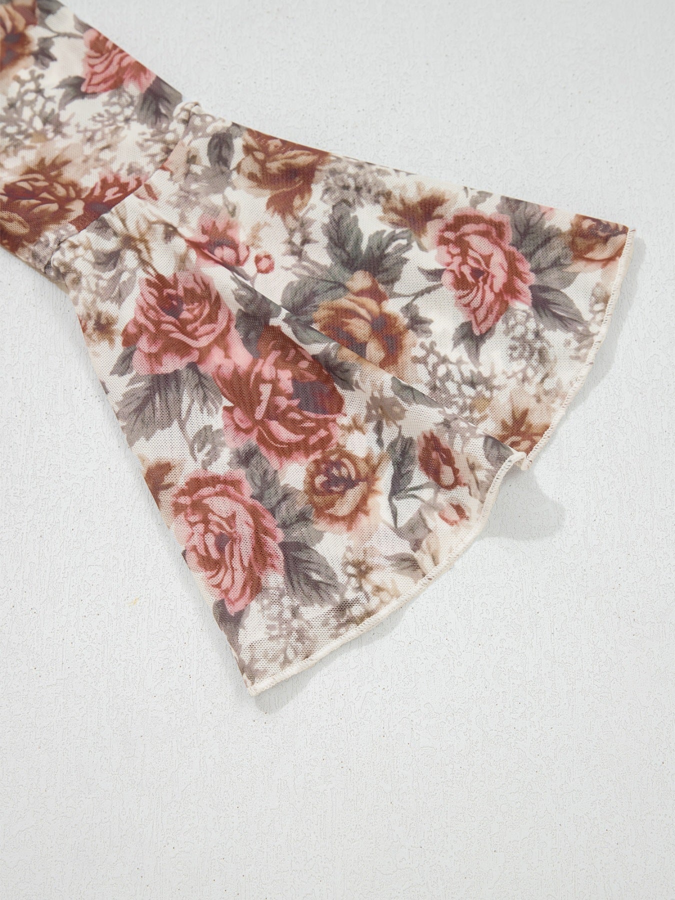 Charming floral mesh blouse with ruffled bell sleeves and a tie detail.