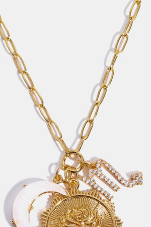 Gold chain pendant necklace with moon, sun, and Scorpio zodiac sign charms.