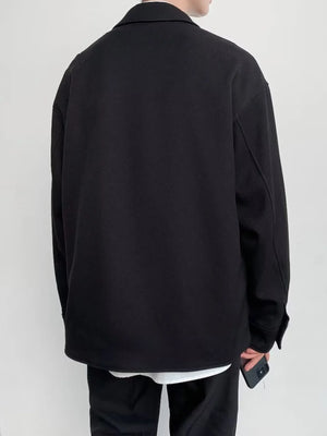 Black oversized button-down jacket with a collar and long sleeves.